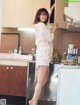 A woman standing in a kitchen next to a sink.