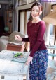 A woman standing in front of a table holding a spoon.