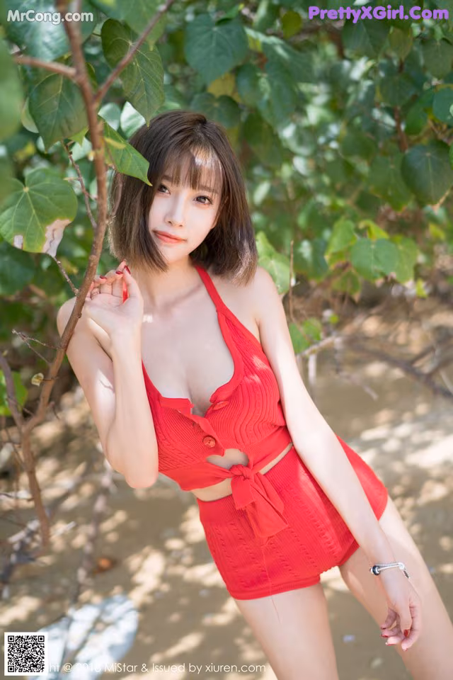 A woman in a red bathing suit posing for a picture.