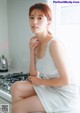 A woman sitting on top of a kitchen counter next to a stove.