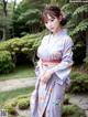 A woman in a purple kimono posing for a picture.