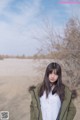 A woman standing in the middle of a desert.