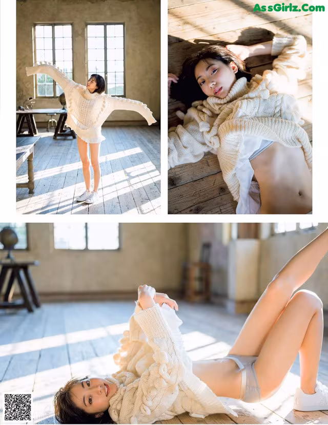 A woman laying on the floor in a white sweater.