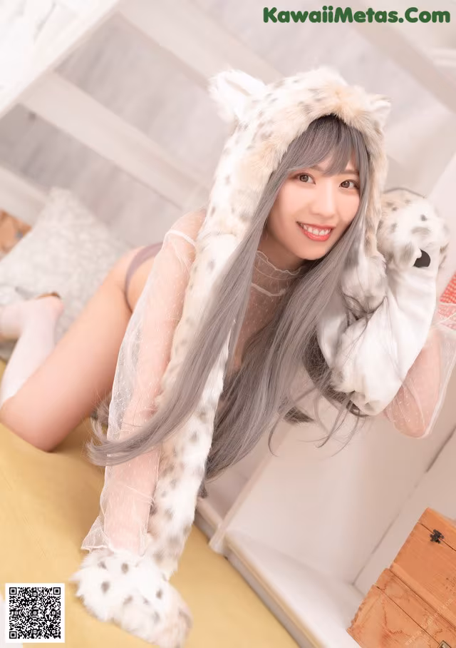 A woman in a leopard costume laying on a bed.