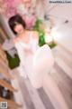 A woman in a white dress sitting on a wooden staircase.