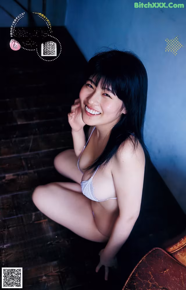 A woman in a white bra and panties sitting on a chair.