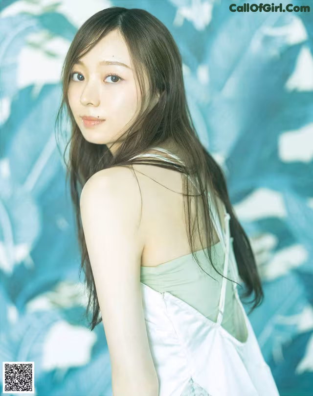 A woman in a white dress posing for a picture.