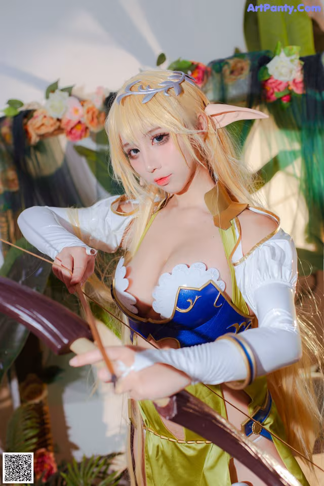 A woman dressed in a costume holding a bow and arrow.