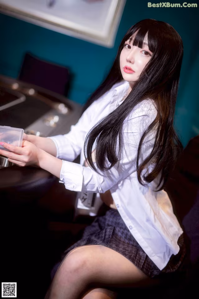 A woman sitting at a table holding a cup of coffee.