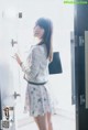 A woman standing in front of a door holding a briefcase.