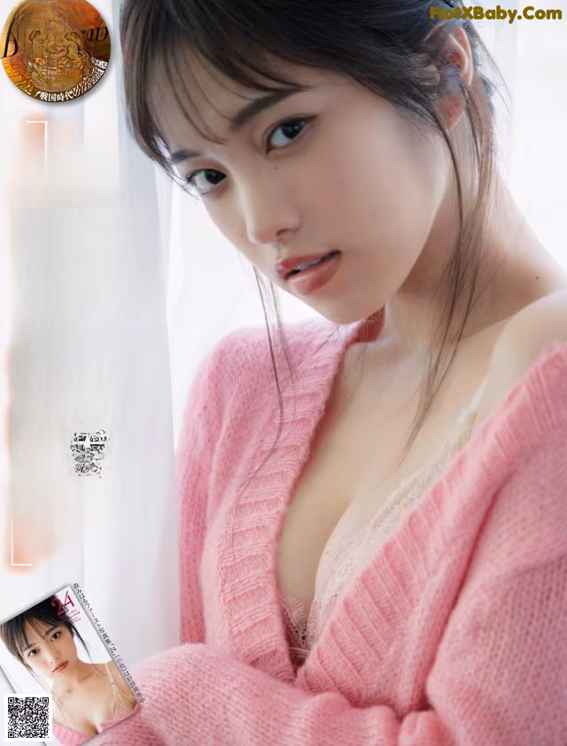 A woman in a pink sweater is posing for the camera.