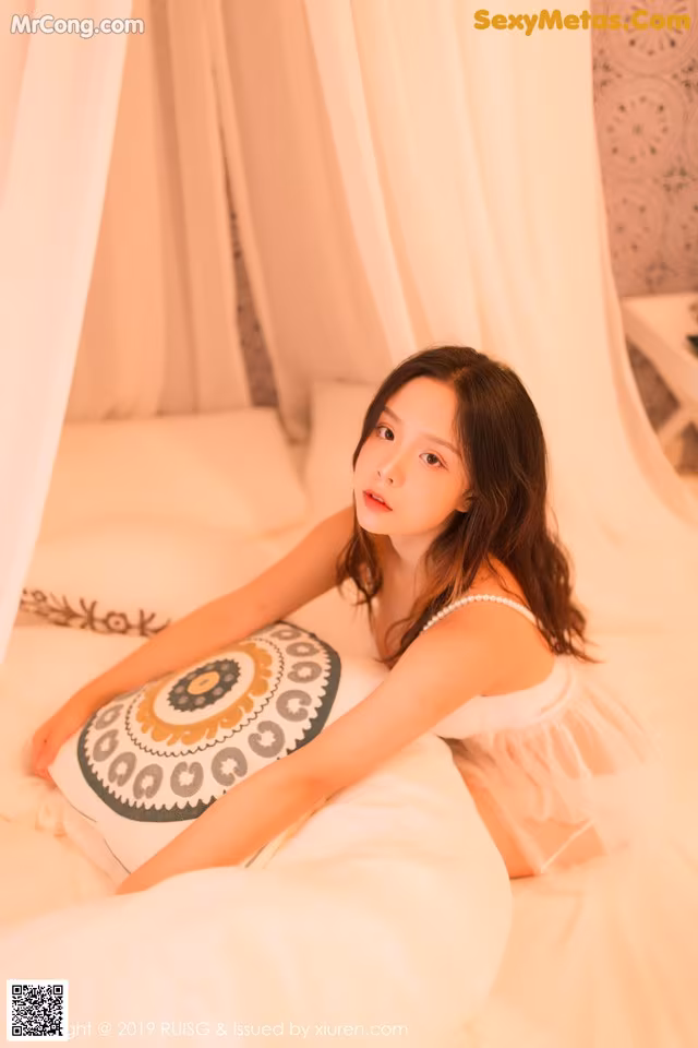 A woman laying on a bed with a pillow.